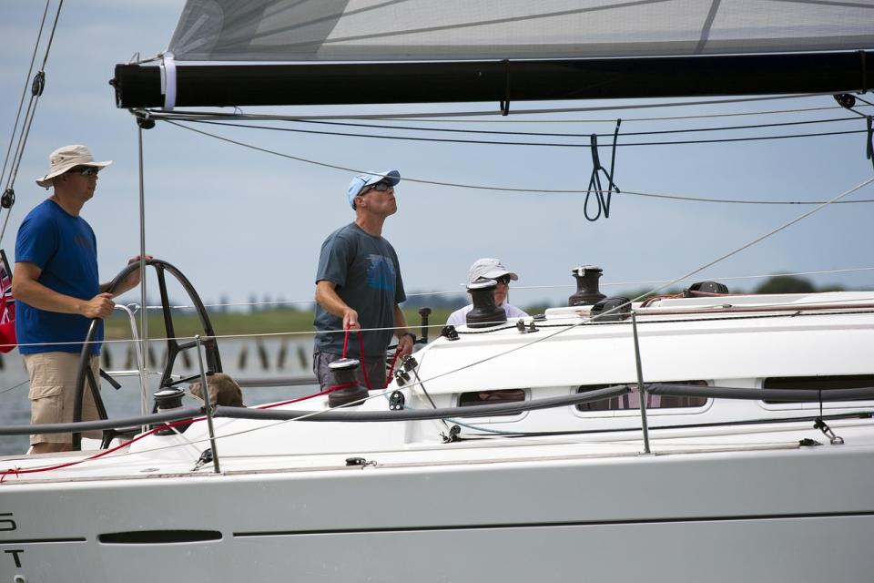 Crew am Steuer einer Segelyacht