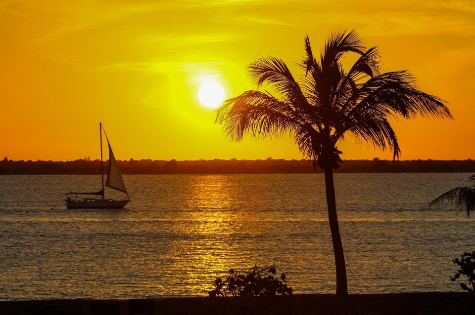 Segelboot und Palme im karibischen Sonnenuntergang