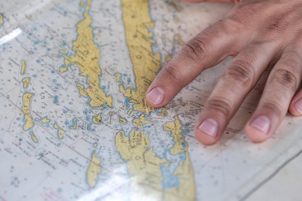 Hand zeigt auf eine Seekarte