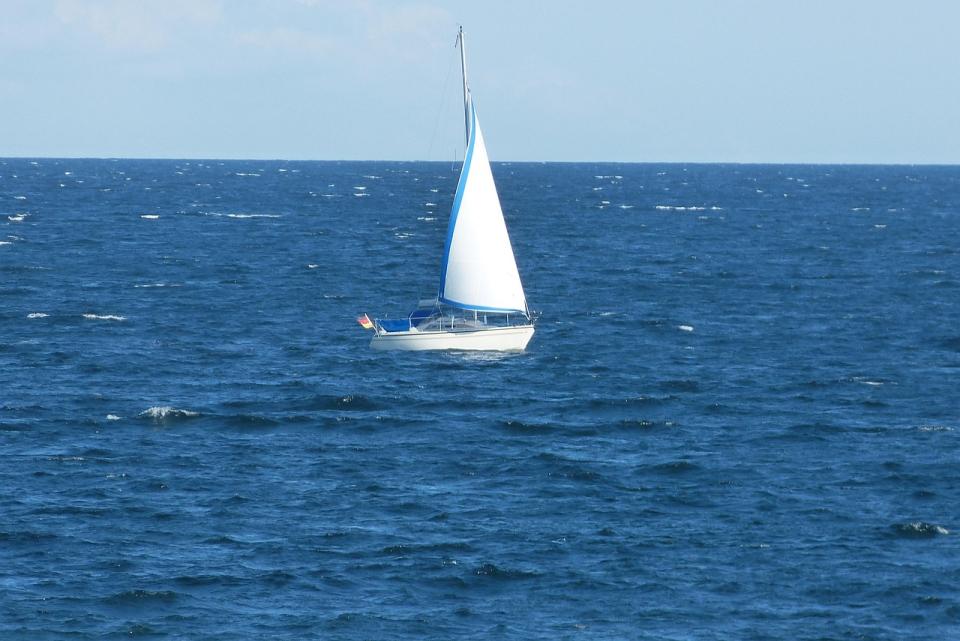 Segelboot mit weißem Segel auf blauer Ostsee